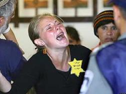 A settler cries and shouts at police officers in Atzmona